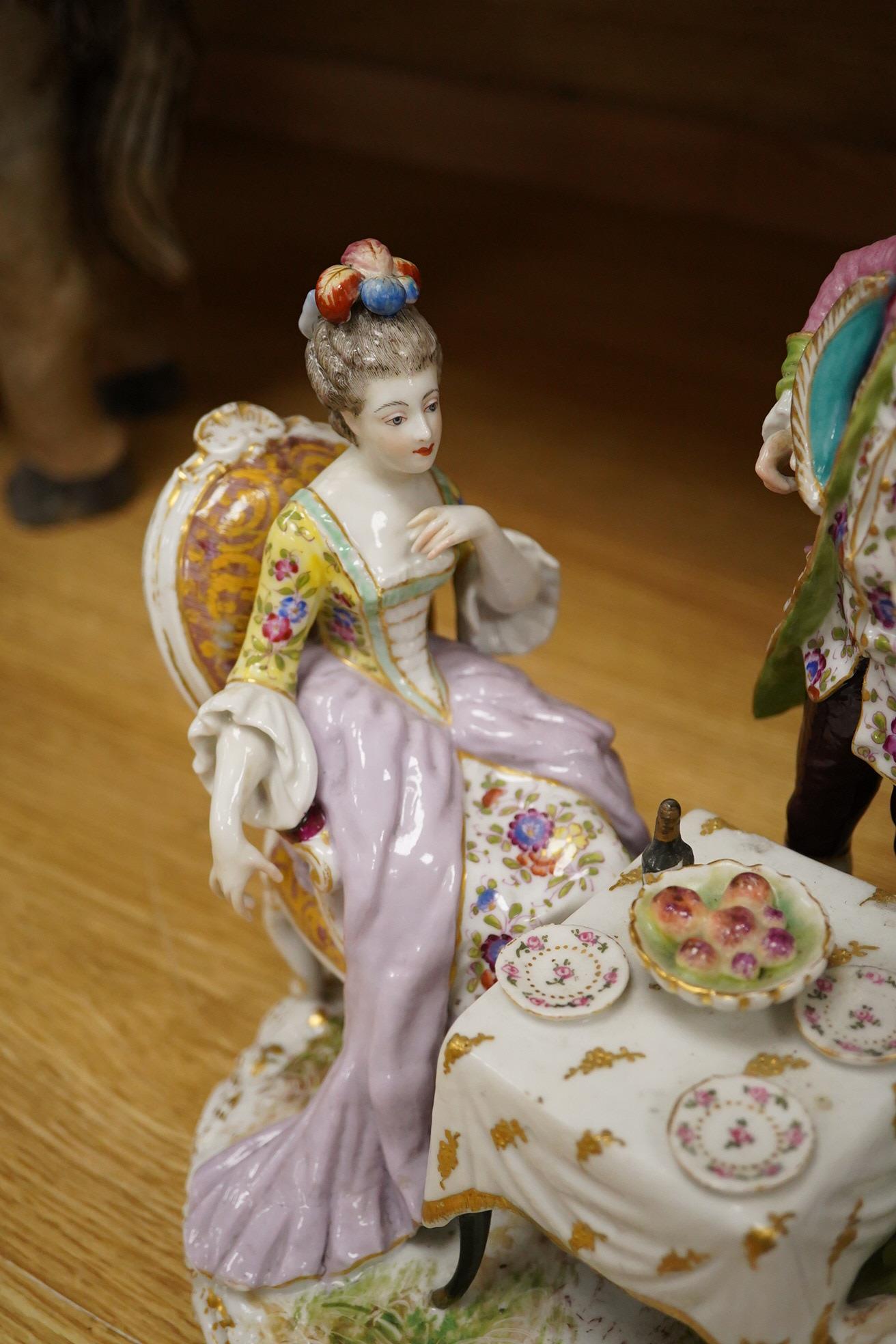 A 19th century Dresden porcelain group of three figures at a table, 24cm high